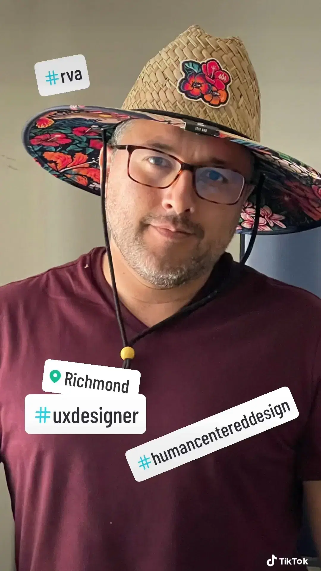 Andrei smiling wearing a summer flowered hat and a burgundy t-shirt